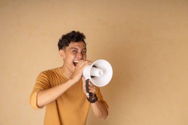 Genç bir adam enerji dolu bir şekilde iletişim kurmak için megafon kullanıyor..