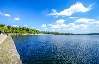 Moehnesee 'deki tarihi baraj duvarından bak. Moehne Barajı ve gölün etrafındaki doğa..
