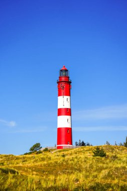 Kuzey Frizya adası Amrum 'daki kum tepelerinin manzarası. Kuzeyde manzara var. Kuzey Denizi adasında deniz feneri olan bir doğa..