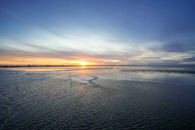 Dagebuell yakınlarındaki manzara. Kuzey Denizi kıyısında gün doğumu olan doğa. Denizde yükselen güneş.