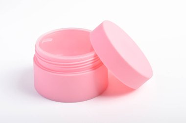 Beyaz arka planı açık kapaklı pembe kozmetik kavanoz kabı. Güzellik ve sağlık için boş ürün şablonu