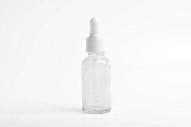 Beyaz arka planda cam damlatıcı şişesi var. Paketleme modeli