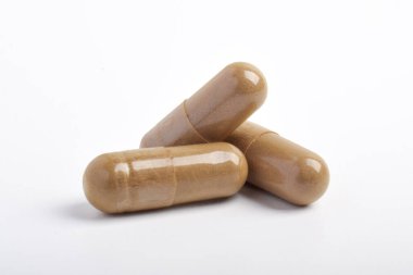 Beyaz arkaplanda izole edilmiş vitamin kapsülleri yığını