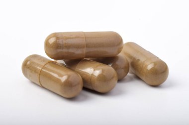 Beyaz arkaplanda izole edilmiş vitamin kapsülleri yığını