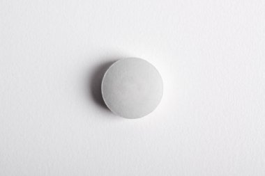 Beyaz arkaplanda izole edilmiş bir hap, üst görünüm