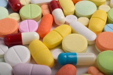 Renkli hapların, tabletlerin ve kapsüllerin yakın çekimleri, sağlık, eczane ve tıbbi tedavi kavramları için çeşitli ilaç ve takviyeleri göstermektedir..