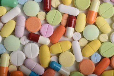 Renkli hapların, tabletlerin ve kapsüllerin yakın çekimleri, sağlık, eczane ve tıbbi tedavi kavramları için çeşitli ilaç ve takviyeleri göstermektedir..