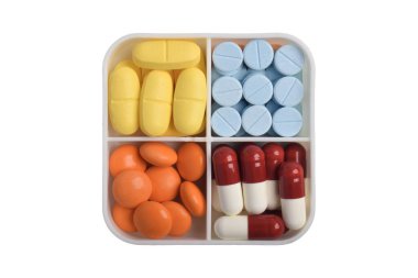 Farklı renklerde haplar ve kapsüller beyaz arka planda farklı ilaç kutuları, üst görünüm. İlaç ve sağlık desteği kavramı.