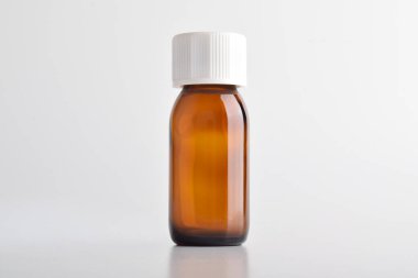 Beyaz arka planda izole edilmiş kahverengi cam şişe..