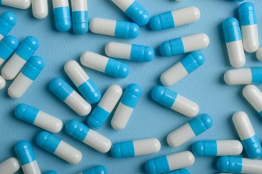 Mavi arkaplan üzerinde ilaç kapsülleri, üst görünüm