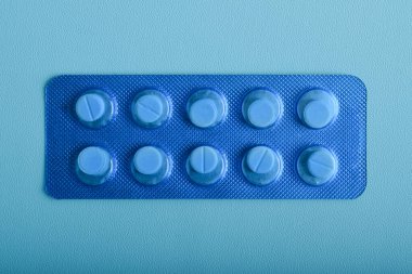 Haplar, mavi tabletler mavi arka planda izole edilmiş, üst görünüm, sağlık ve tıp konsepti