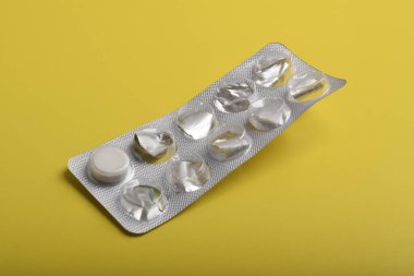 Sarı arka planda izole edilmiş boş su toplayıcı hapları.