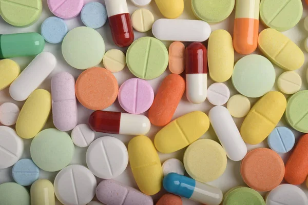Renkli hapların, tabletlerin ve kapsüllerin yakın çekimleri, sağlık, eczane ve tıbbi tedavi kavramları için çeşitli ilaç ve takviyeleri göstermektedir..