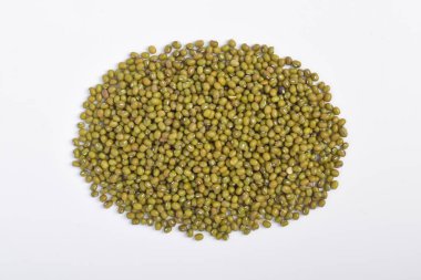 Ovallarda beyaz arka planda sıralanmış mung fasulyelerinin üst görüntüsü.