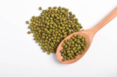 Beyaz arka planda izole edilmiş tahtadan bir kaşıkta Mung fasulyesi. Üst görünüm