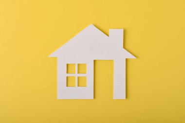 Sarı arka planda minimal ev simgesi. Gayrimenkul, ev sahipliği, emlak yatırımı, konut piyasası, konut yaşamı ve fotokopi alanı olan modern konut kavramı.