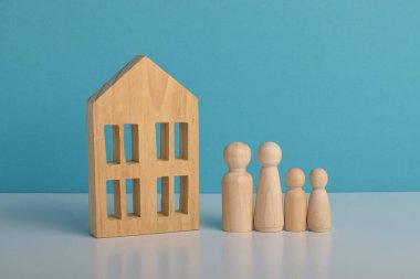 Aile korumasını, ev mülkiyetini, emlak yatırımını, ipotek finansmanını ve emlak yönetimi kavramını temsil eden ahşap ev sembolü.