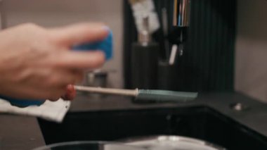 Ekşi hamuru pişirmede kullanılan spatulayı temizlerken, dokuları renklendirirken ve suyun akışını belirlerken, huzurlu bir mutfak atmosferi yaratırken ellerinizi yakın plan çekin.