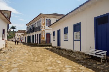 Paraty, RJ, Brezilya - 10.29.2025: tarihi köy, eski kasaba kaldırım taşı caddesinde yürüyen turistler.