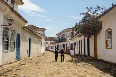 Paraty, RJ, Brezilya - 10.29.2025: tarihi köy, eski kasaba kaldırım taşı caddesinde yürüyen turistler.
