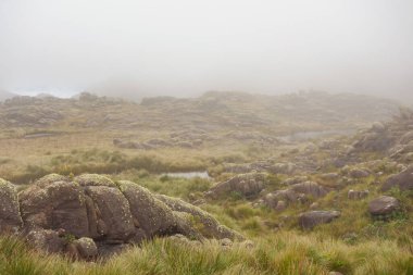 Sis altındaki Itatiaia Ulusal Parkı 'nın yüksek rakım bölgesindeki kayalık dağ manzarası. Rio de Janeiro, Brezilya.