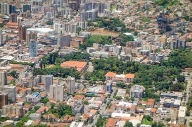 Gökdelenler ve yeşil dağların arasına kurulmuş binalar. Pocos de Caldas, Minas Gerais, Brezilya. Panoramik hava görüntüsü.