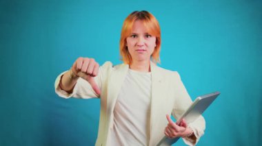 Elinde dizüstü bilgisayarı olan ciddi genç bir iş kadını. Ve mavi arka plandaki sonuçtan hoşnutsuzluğunu ve memnuniyetsizliğini dile getiriyor.