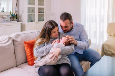 Mutlu yeni anne babalar, yeni doğan değerli bebeklerini kucağına alıp sıcak bir ev ortamında sevgi, ilgi ve aile bağlarını gösteriyorlar. Yeni hayatı ve ebeveynliği kutluyorlar.