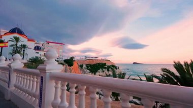 Benidorm, İspanya 'da Akdeniz' in balkonundan büyüleyici manzara, beyaz balyozlar, geleneksel mimari ve arka planda kayalıklar ile denizin üzerindeki güzel günbatımını yakalıyor.