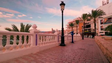 Benidorm, İspanya 'daki ünlü balkon del Mediterraneo manzarası boyunca yürüyüp güzel ve renkli bir günbatımı sırasında şehrin gökyüzü ve midilli sahili manzarasını gözler önüne seren bakış açısı.