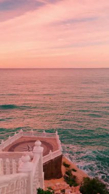 Benidorm, İspanya 'daki Akdeniz' in balkonundan büyüleyici manzara, güzel pembe ve turuncu günbatımı boyunca canlı şehir manzarası ve sakin deniz manzarası, popüler bir turizm beldesi.