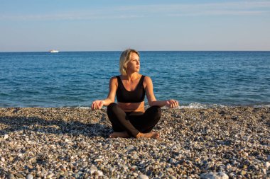 Kumsalda egzersiz yapan bir kadın.