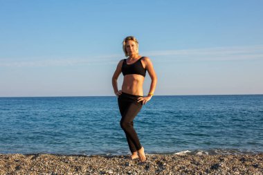 Kumsalda egzersiz yapan bir kadın.