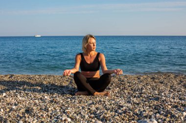 Kumsalda egzersiz yapan bir kadın.