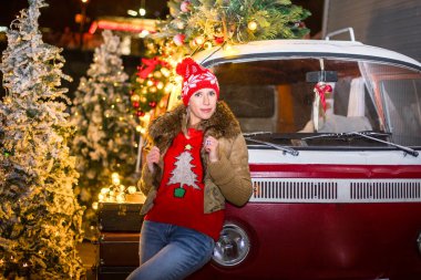 Yeni yıl süslemeli arabasıyla otoparktaki kız.