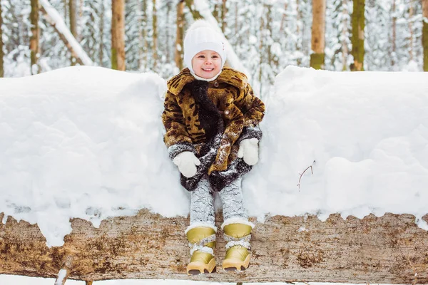 Зимний портрет милой улыбающейся девочки на прогулке в солнечном снежном лесу — стоковое фото