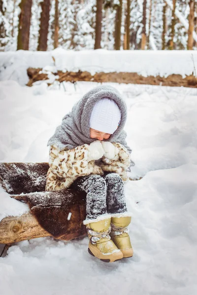 Winterporträt des niedlichen lächelnden Kindermädchens auf dem Spaziergang im sonnigen, verschneiten Wald — Stockfoto