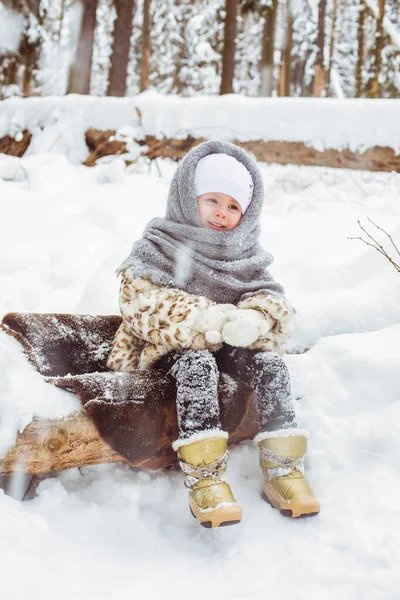Ritratto invernale di ragazza bambino carina sorridente sulla passeggiata nella foresta innevata soleggiata — Foto Stock