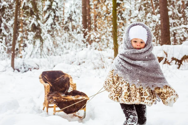 Zimowy portret uroczej uśmiechniętej dziewczynki na spacerze w słonecznym, śnieżnym lesie — Zdjęcie stockowe