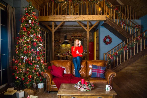 Noel ağacının önünde oturan kız.