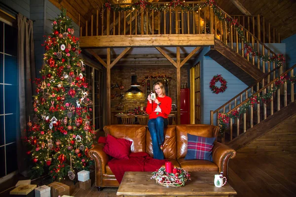 Noel ağacının önünde oturan kız.