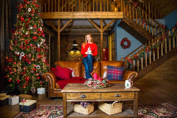 Noel ağacının önünde oturan kız.