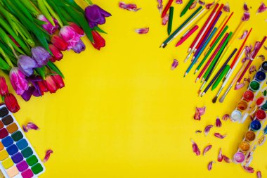 Aquarelle paleti ile yaratıcı düzen, sarı arkaplanda boya fırçaları
