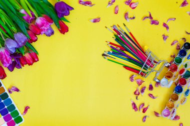 Aquarelle paleti ile yaratıcı düzen, sarı arkaplanda boya fırçaları