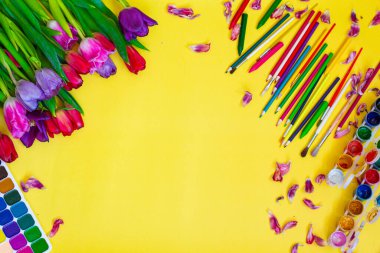 Aquarelle paleti ile yaratıcı düzen, sarı arkaplanda boya fırçaları