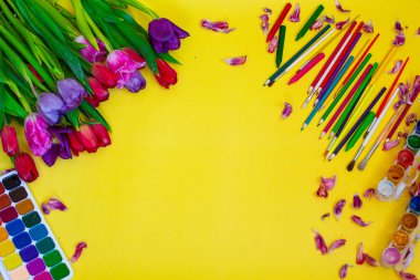 Aquarelle paleti ile yaratıcı düzen, sarı arkaplanda boya fırçaları
