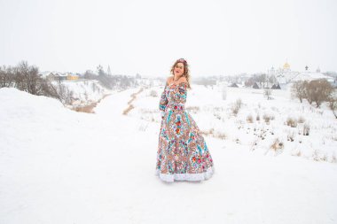 Güzel Rus kızı, ulusal bir kış elbisesi içinde.