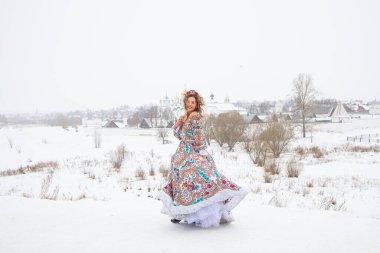 Güzel Rus kızı, ulusal bir kış elbisesi içinde.