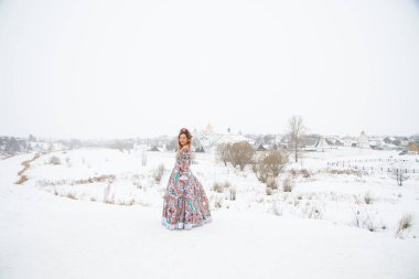 Güzel Rus kızı, ulusal bir kış elbisesi içinde.