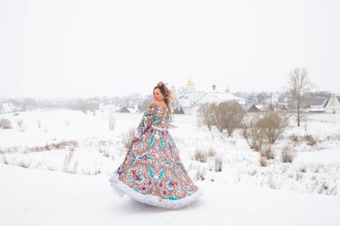 Güzel Rus kızı, ulusal bir kış elbisesi içinde.